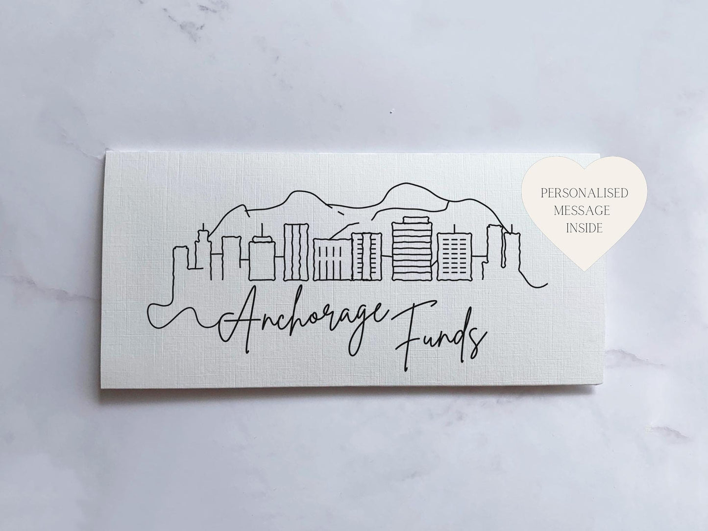 a white card with a black ink drawing of a city