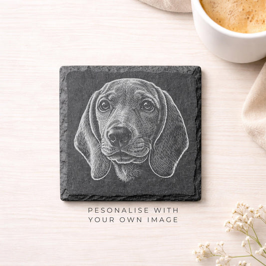 A black and white engraved image of a dog's face on a slate coaster, accompanied by the text "PERSONALISE WITH YOUR OWN IMAGE".