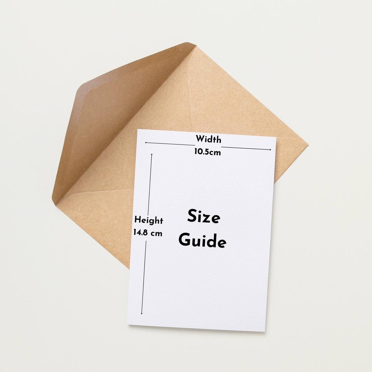 a white card with a brown envelope placed on a white background. The card has a guide size written on it, indicating the dimensions of the card and the envelope.