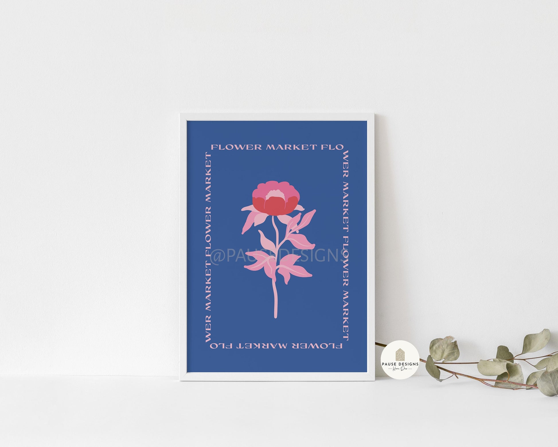 a pink flower on a blue background next to a plant